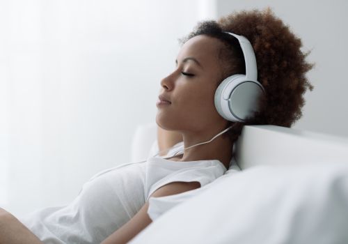woman listening to relaxing music with headphones for stress relief and sleep