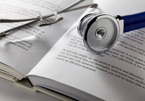 book with a stethoscope and glasses representing medical research and evidence about menopause health