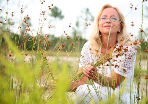 peaceful woman sitting in nature reflecting and feeling confident after menopause