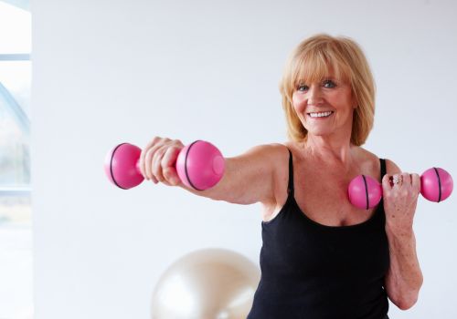 midlife woman doing light dumbbell workout at home for menopause weight management