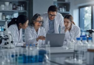 Researchers collaborating in a modern laboratory while analyzing women’s health and menopause research data