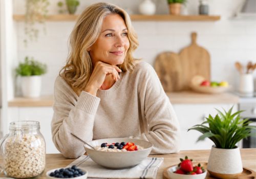 Woman over 50 enjoying a bowl of oatmeal with berries to support cholesterol and metabolic health during menopause